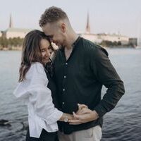 Happy couple embracing by the Alster Lake in Hamburg, Germany during a beautiful summer evening.